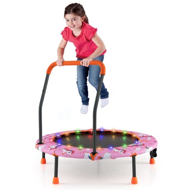 Dziecko skaczące na różowej trampolinie z oświetleniem LED