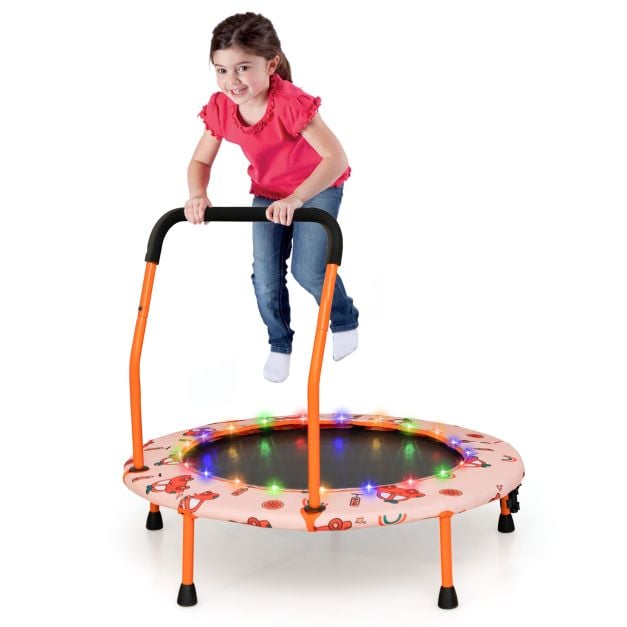 Dziecko skaczące na pomarańczowej trampolinie z oświetleniem LED